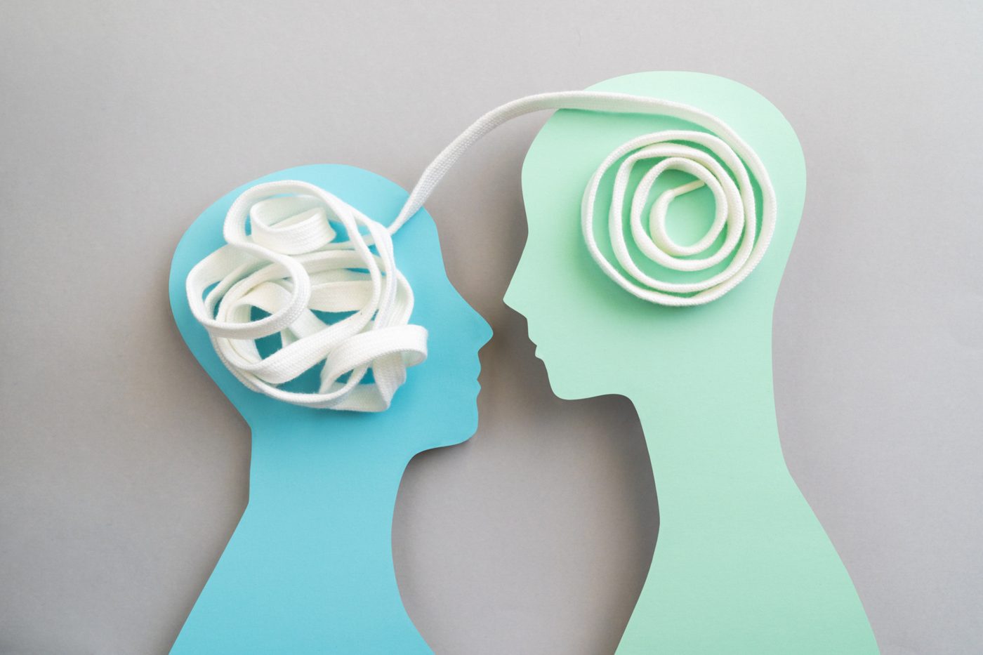 Illustration of two heads connected by a thread that untangles between them