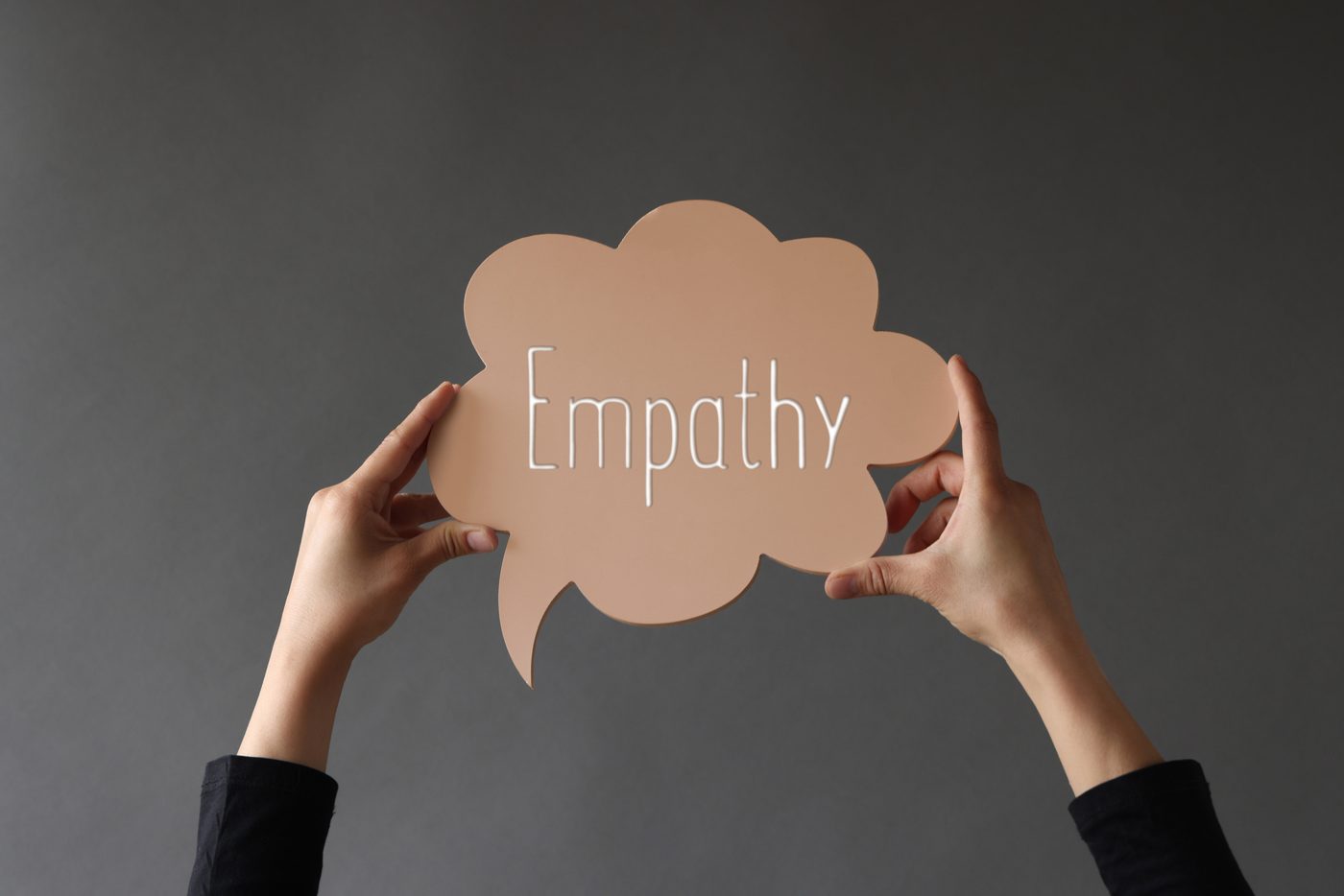 Hands holding a speech bubble reading empathy